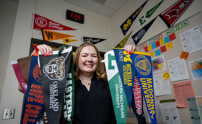 Female student holding up university pennants